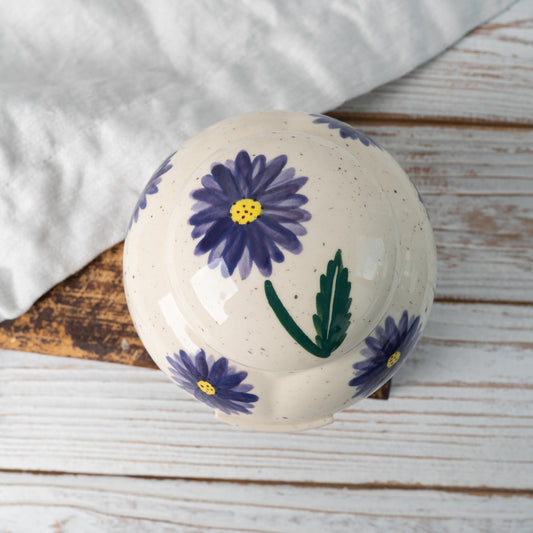 Top-down view of hand-painted ceramic lid with aster floral design for heart keepsake urn