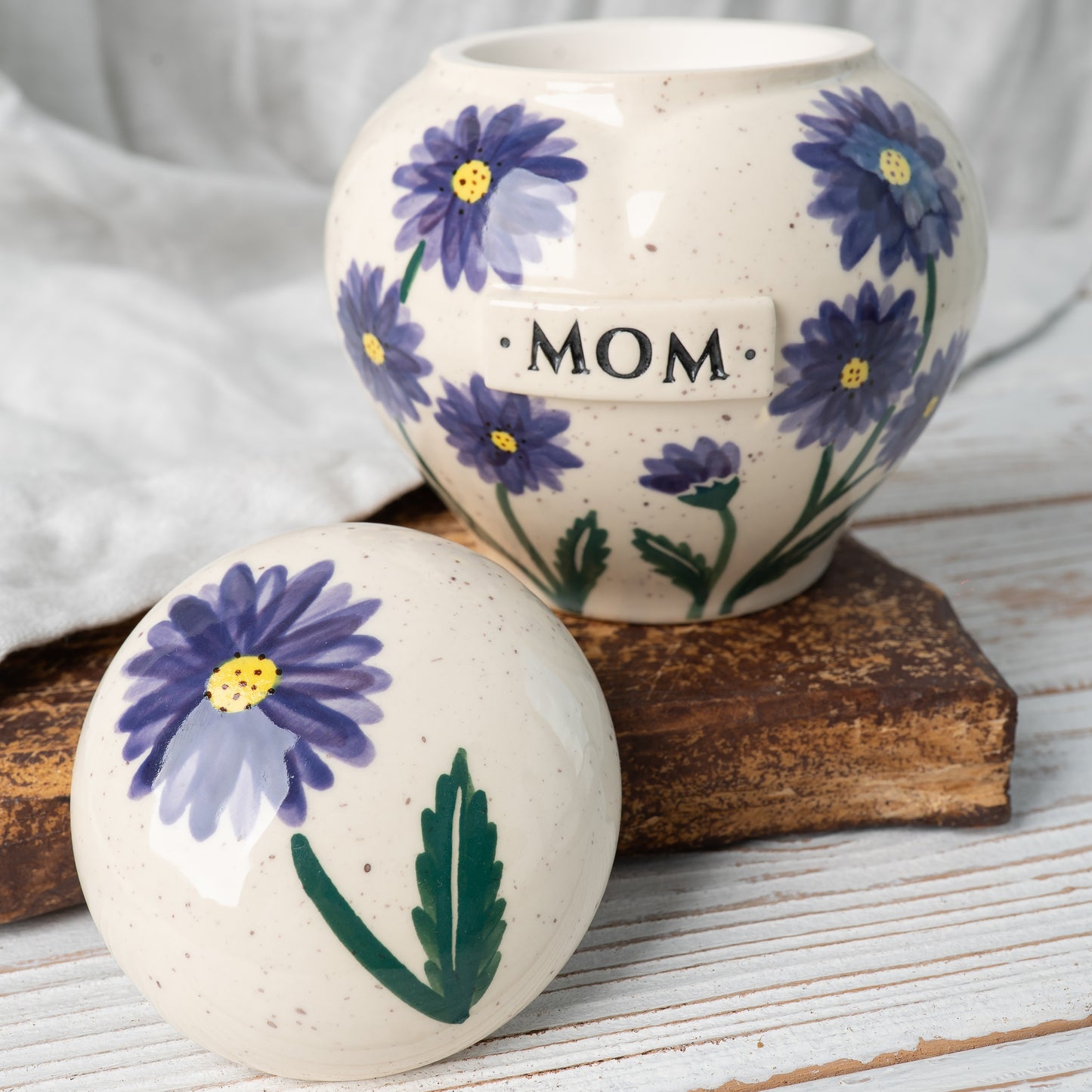 Custom aster flower ceramic memorial urn shown open revealing inner chamber for ashes