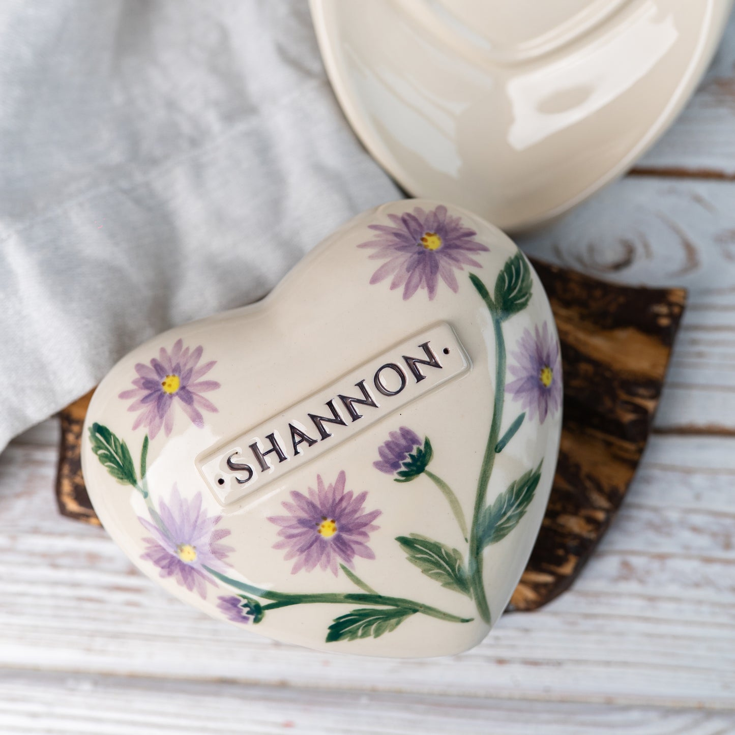 Top view of the ceramic heart urn, showing the detailed purple and white aster petals.