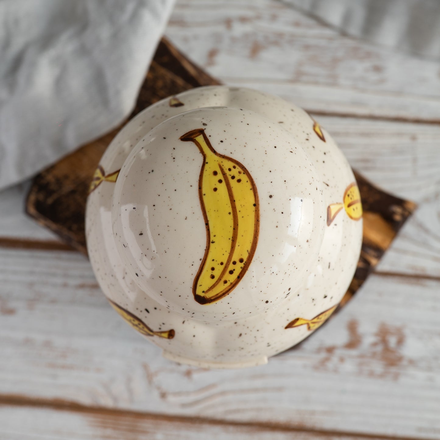 Top-down view of hand-painted ceramic lid with banana lop bunny ear design for pet memorial urn