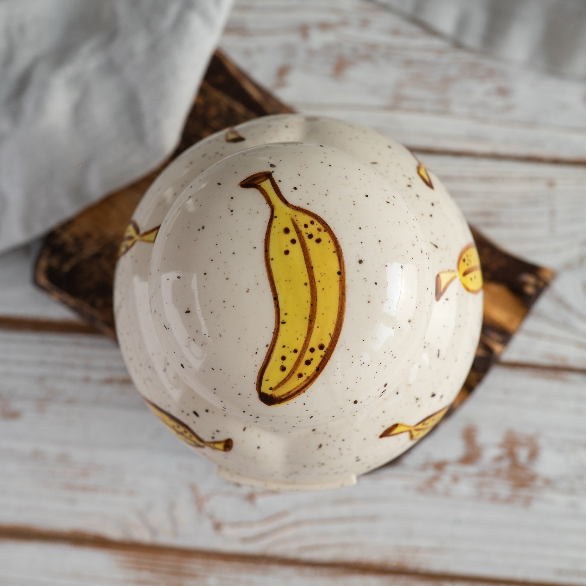 Top-down view of hand-painted ceramic lid with banana lop bunny ear design for pet memorial urn