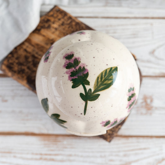 Overhead view of the closed heart-shaped urn showing the hand-painted basil leaf pattern on the lid.