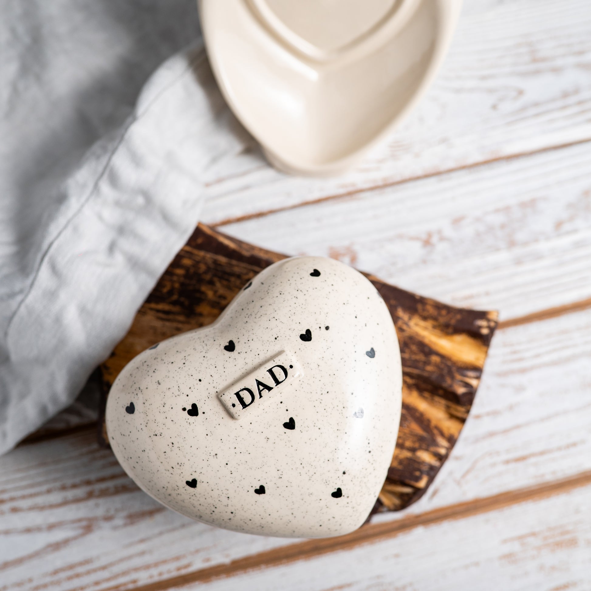 Top view of the heart-shaped urn showing the artisan hand-painted black hearts and glossy finish.