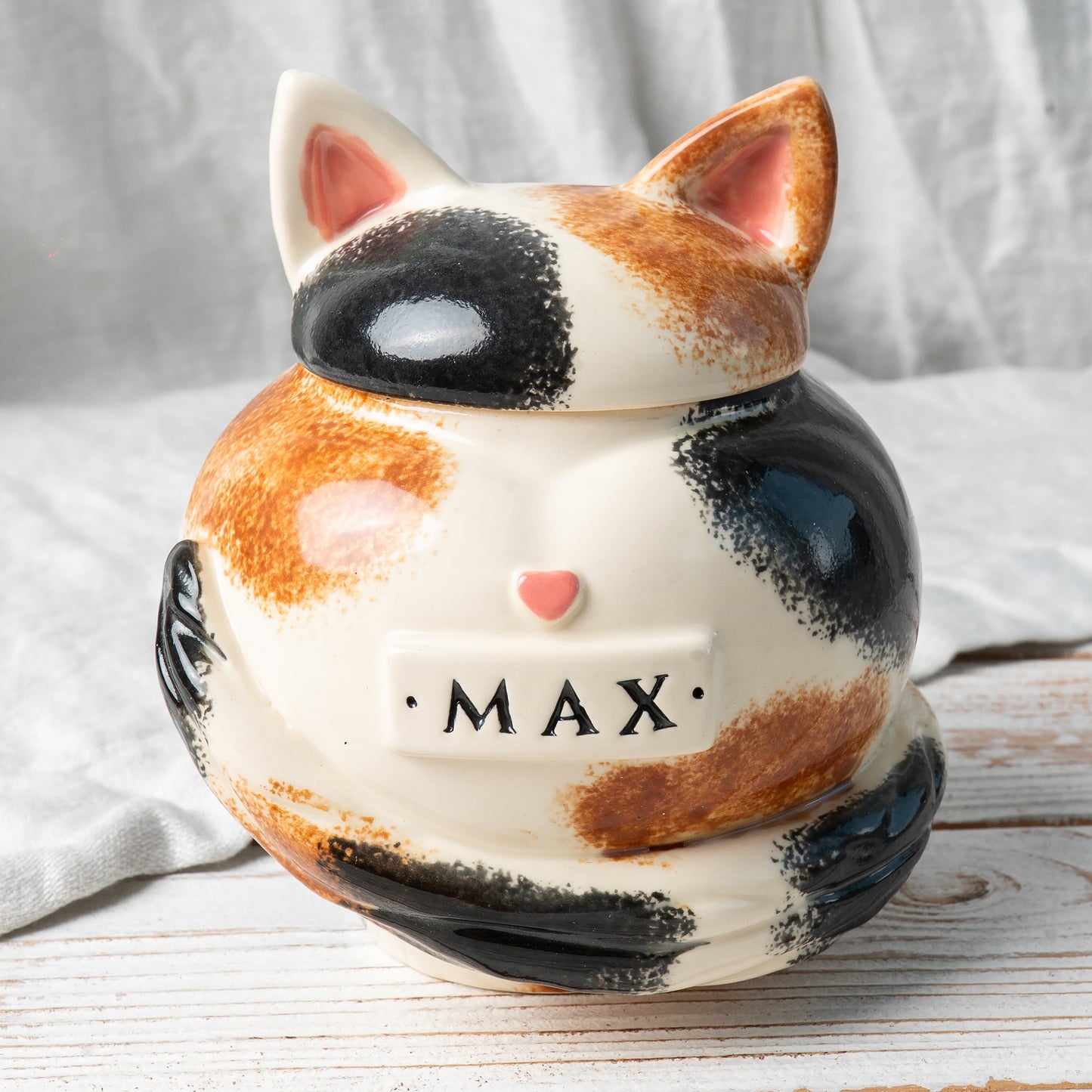 Calico cat heart-shaped ceramic urn for ashes with sculpted cat ears and tail front view