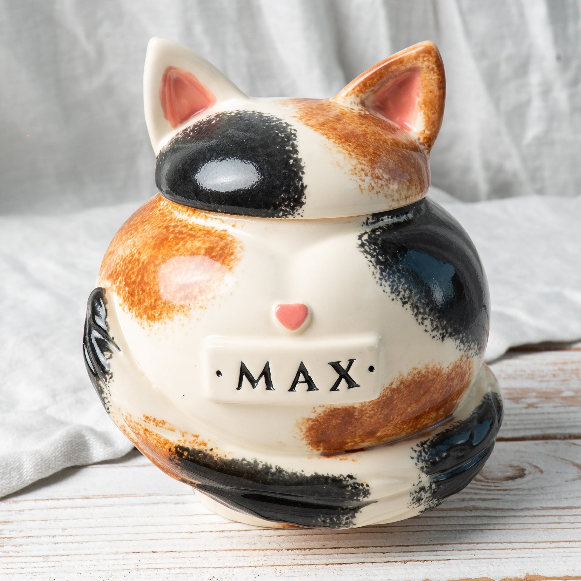 Calico cat heart-shaped ceramic urn for ashes with sculpted cat ears and tail front view