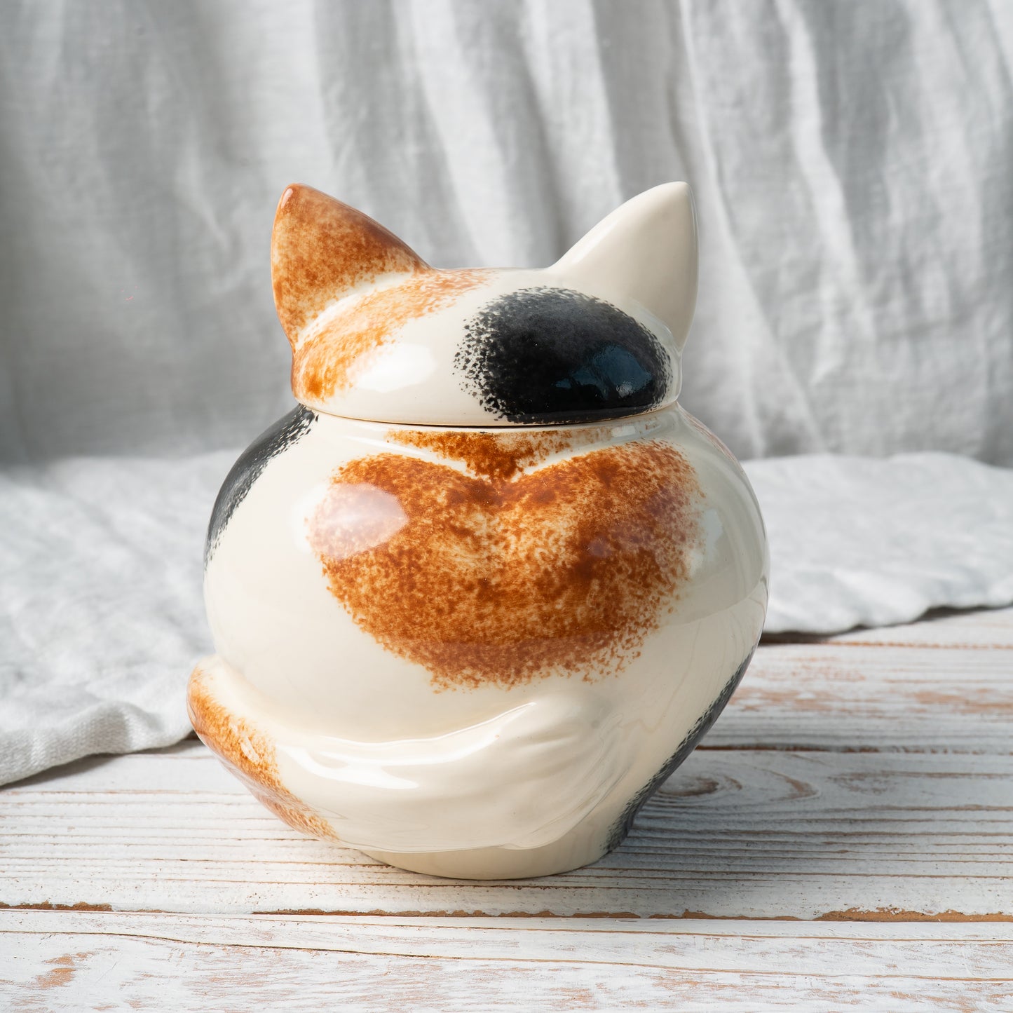 Side view of hand-painted calico cat ceramic pet memorial urn featuring sculpted tail and ears