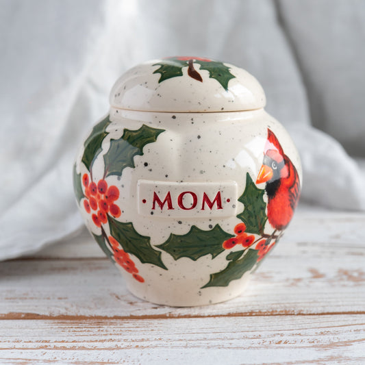 Hand-painted pot-style heart-shaped ceramic pet urn with a red cardinal and holly berries.