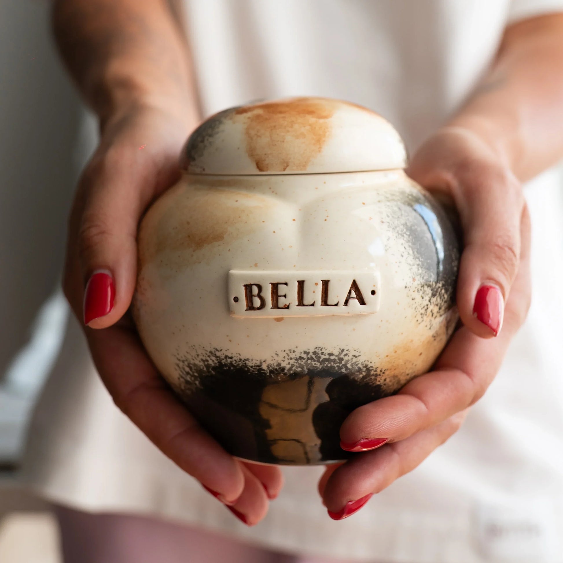 Holding a small Calico cat heart keepsake urn for scale