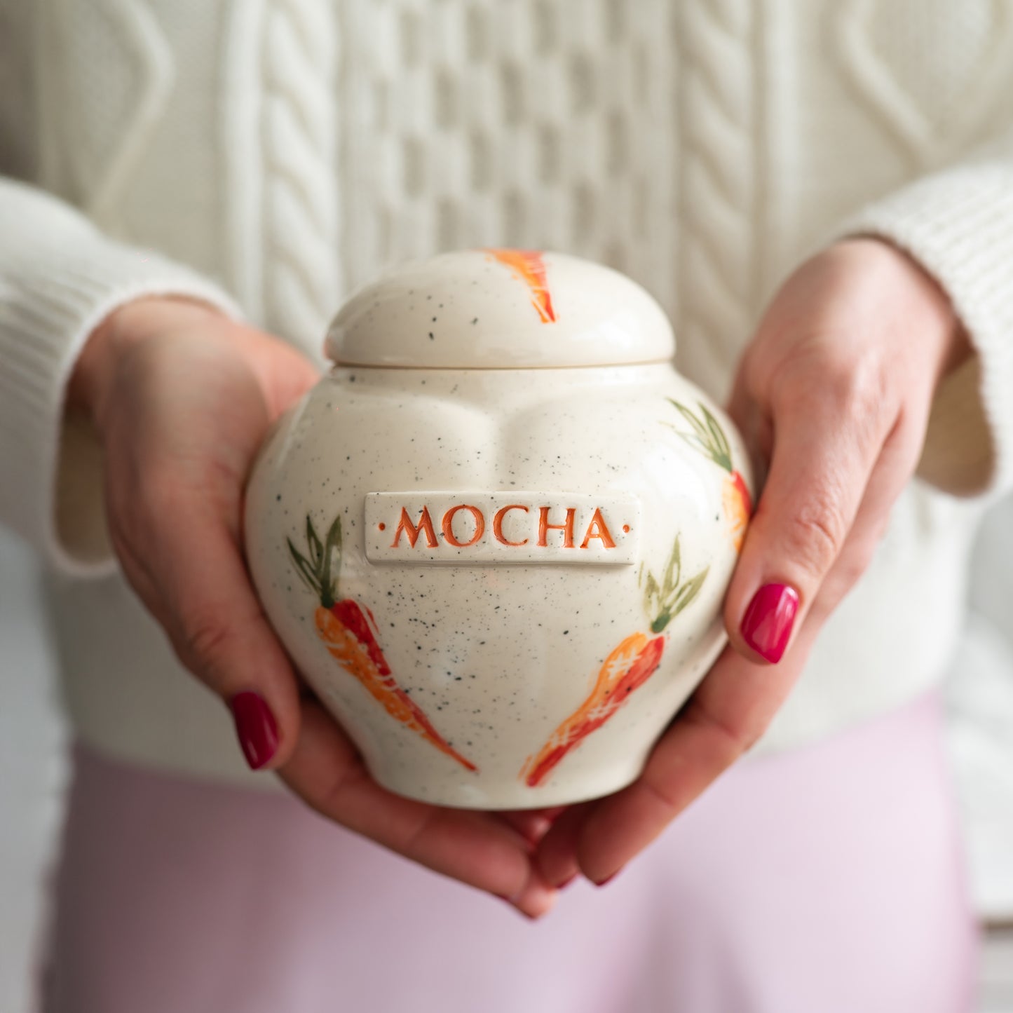 Holding a small carrot heart rabbit keepsake urn for scale