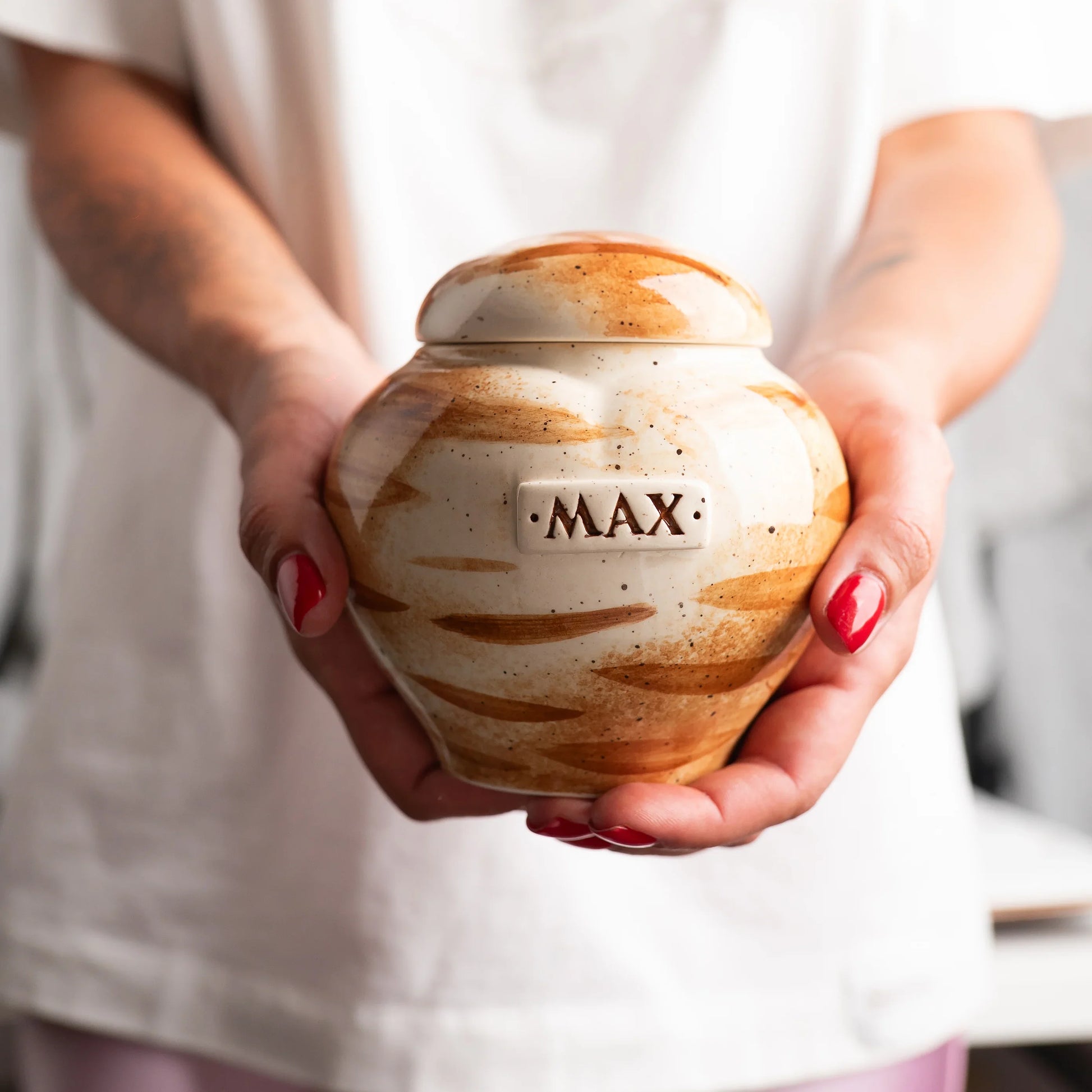 Holding a small ginger cat heart keepsake urn for scale by Mira Ceramics.
