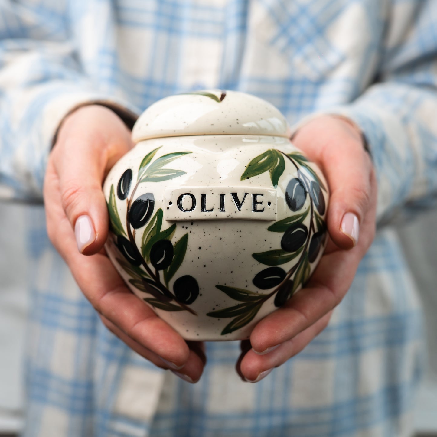 Holding a small size olive leaf heart keepsake urn for scale