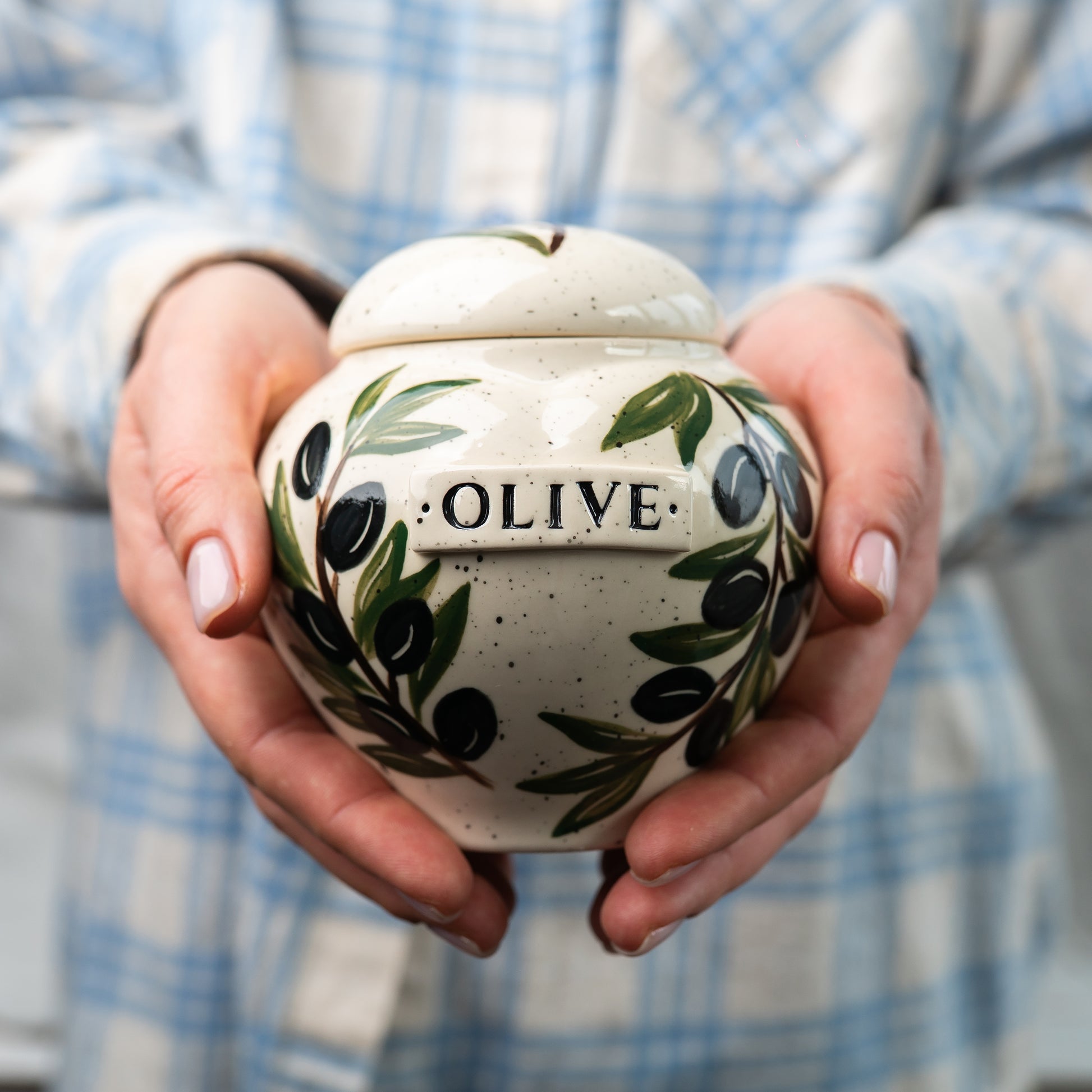 Holding a small size olive leaf heart keepsake urn for scale