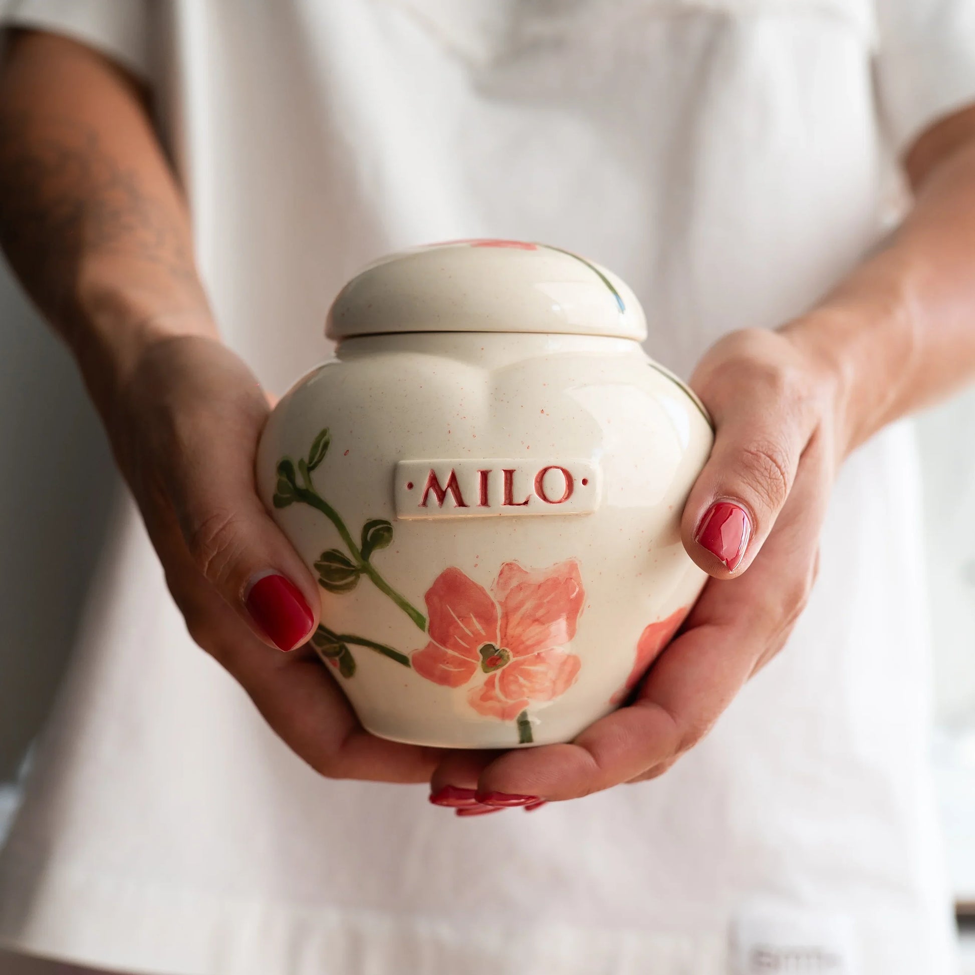 Holding a small orchid heart keepsake urn for scale