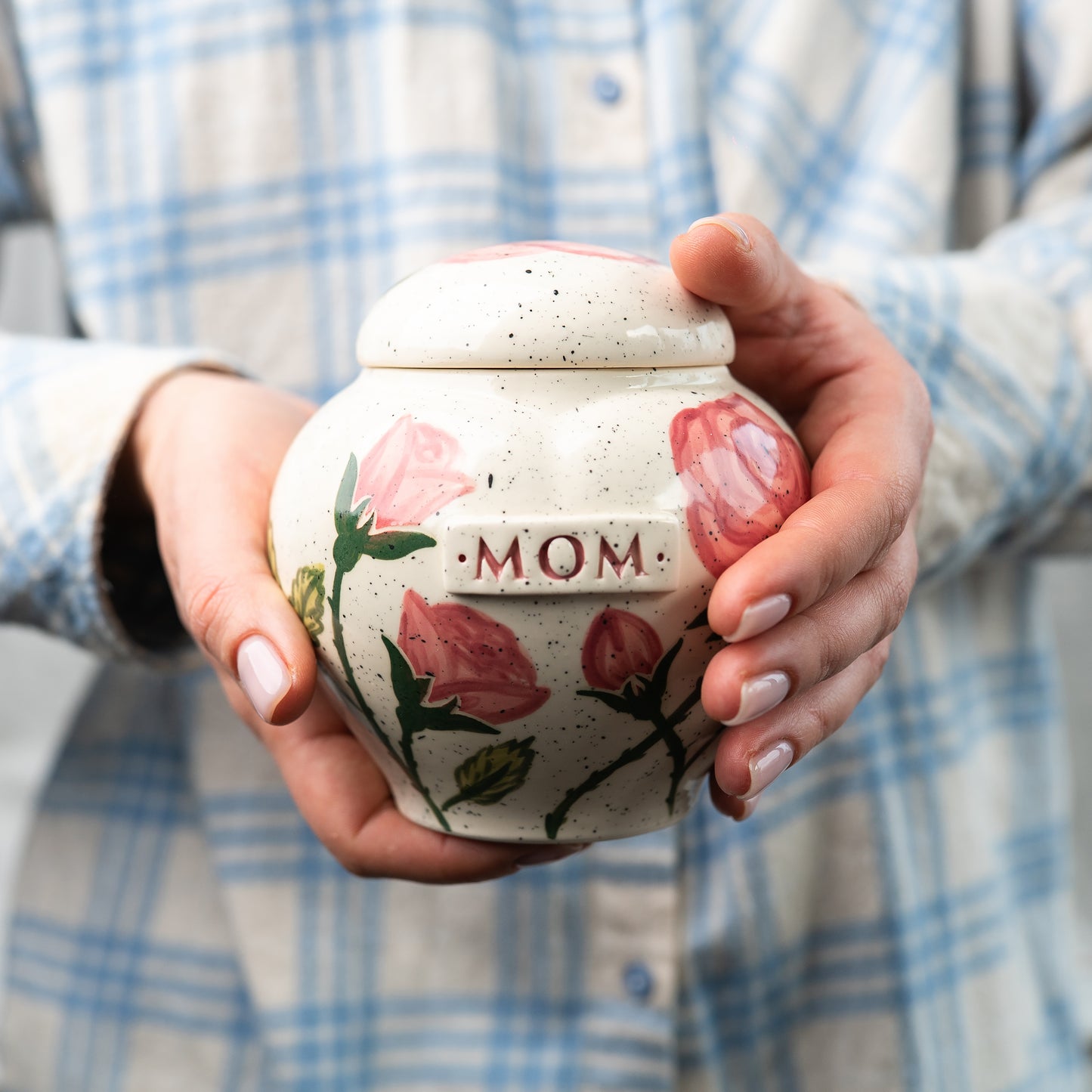 Holding a small pink rose heart keepsake urn for scale