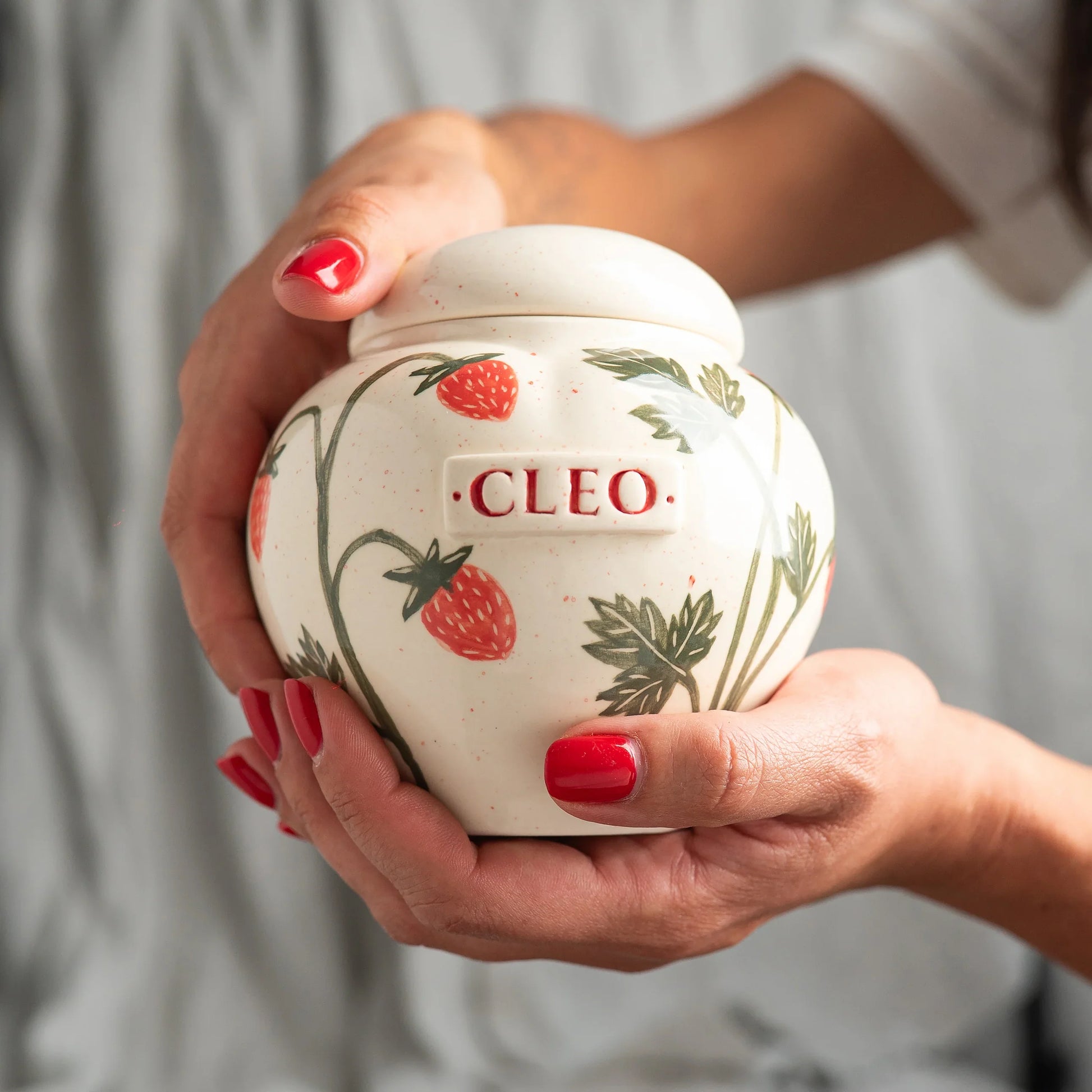 Holding a small strawberry heart keepsake urn for scale