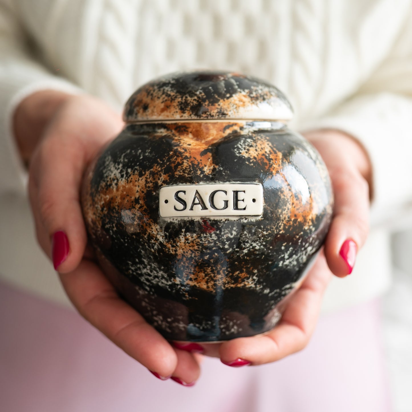 Holding a small tortoiseshell cat heart keepsake urn for scale