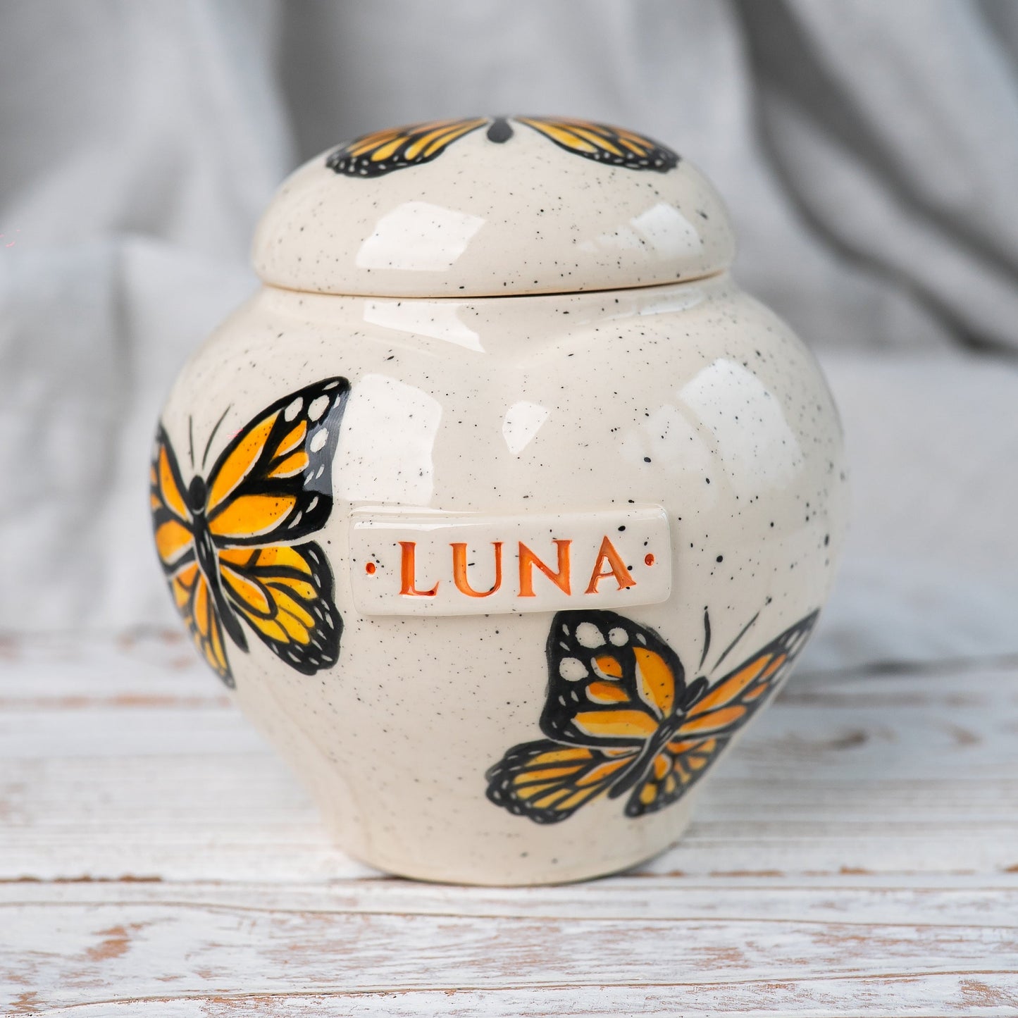 Hand-painted Monarch butterfly ceramic heart urn by Mira Ceramics.