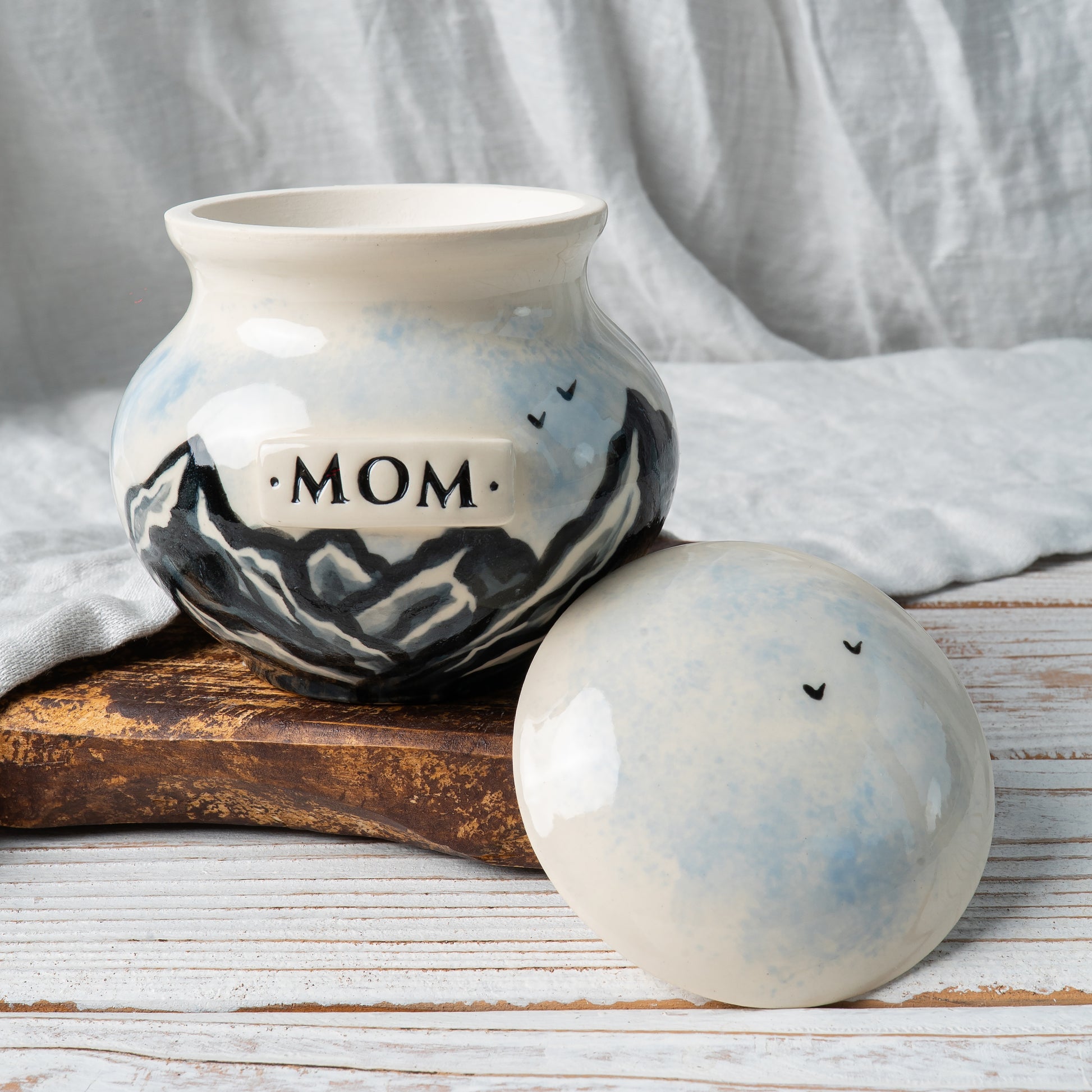 Custom ceramic mountain memorial urn with open lid showing inner chamber for ashes