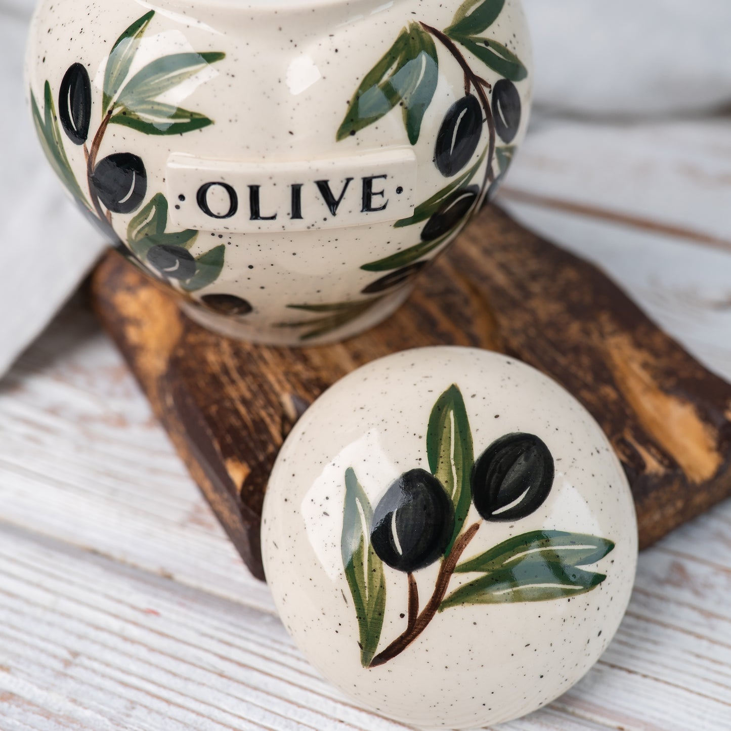 Close-up of open olive branch ceramic heart urn lid by Mira Ceramics.