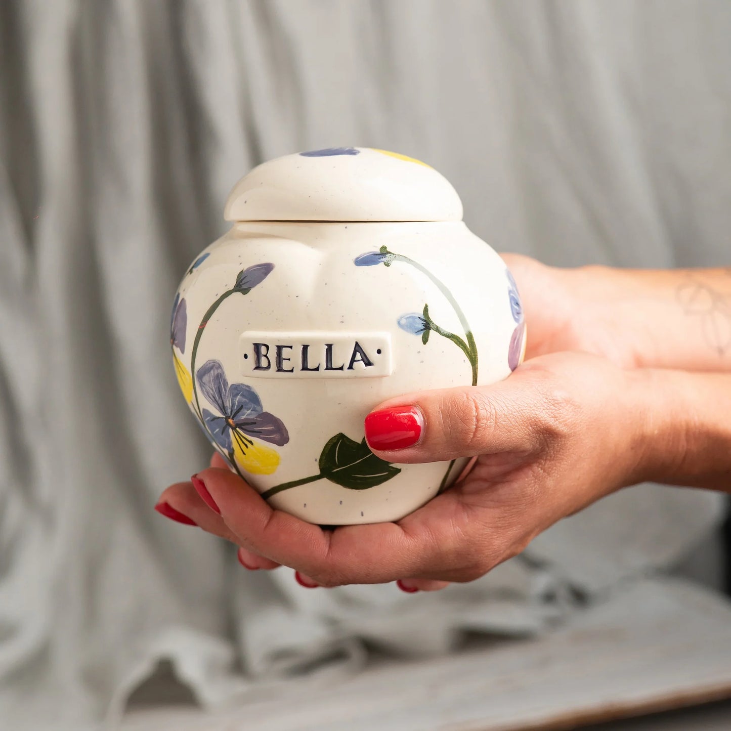Pansies ceramic heart urn in a warm and thoughtful memory corner