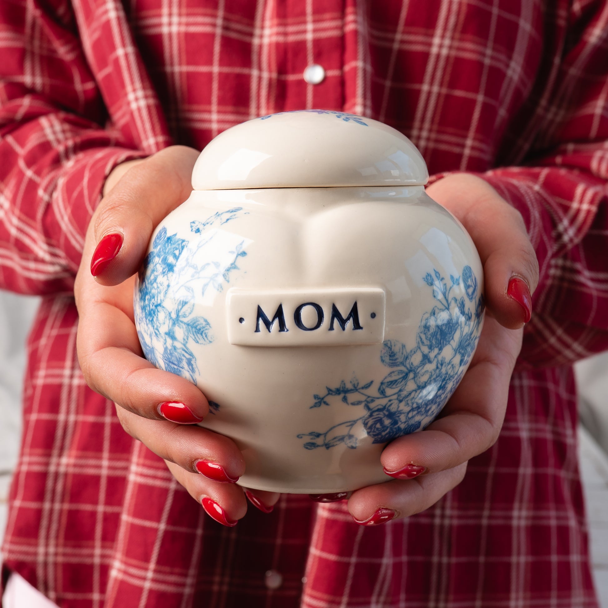 Small custom heart ceramic blue and white floral toile keepsake urn held gently in hands for scale