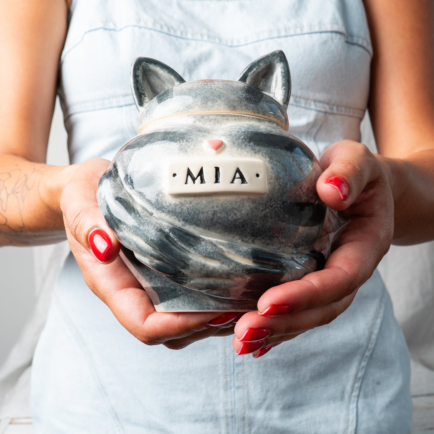 Small custom heart ceramic gray tabby cat keepsake urn held gently in hands for scale
