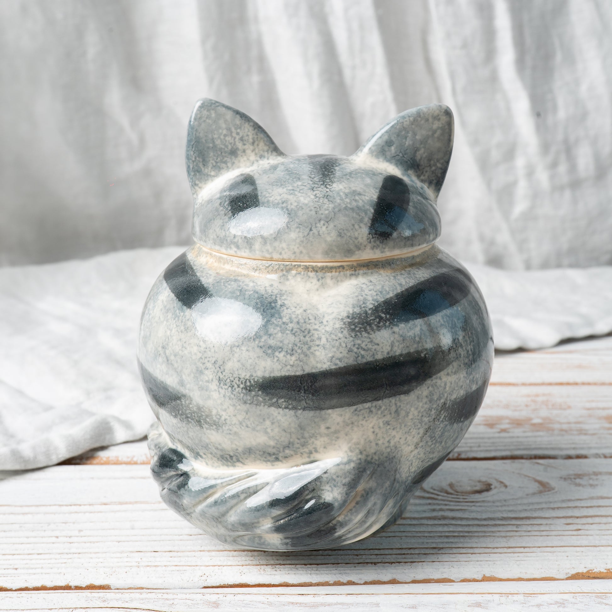 Side view of hand-painted gray tabby cat ceramic pet memorial urn showing striped coat and tail details