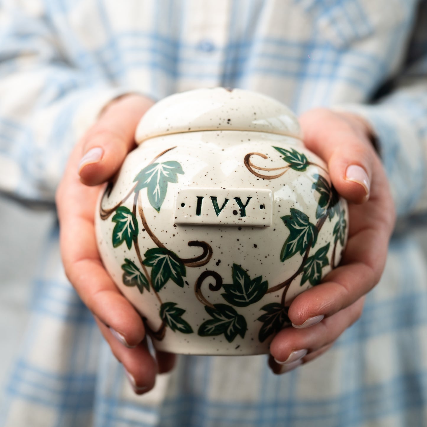 Small custom heart ceramic green ivy pet keepsake urn held gently in hands for scale