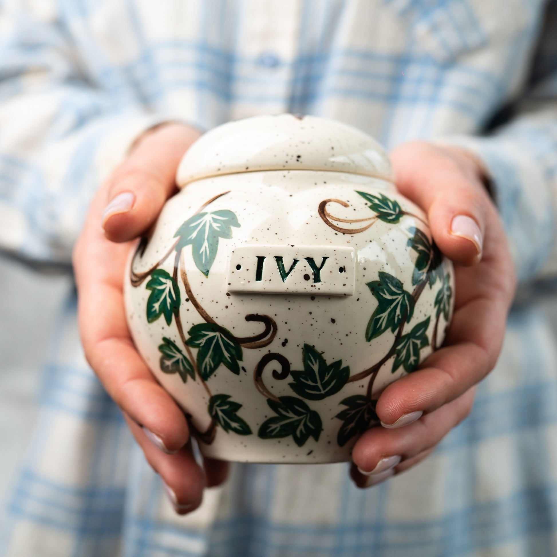 Small custom heart ceramic green ivy pet keepsake urn held gently in hands for scale