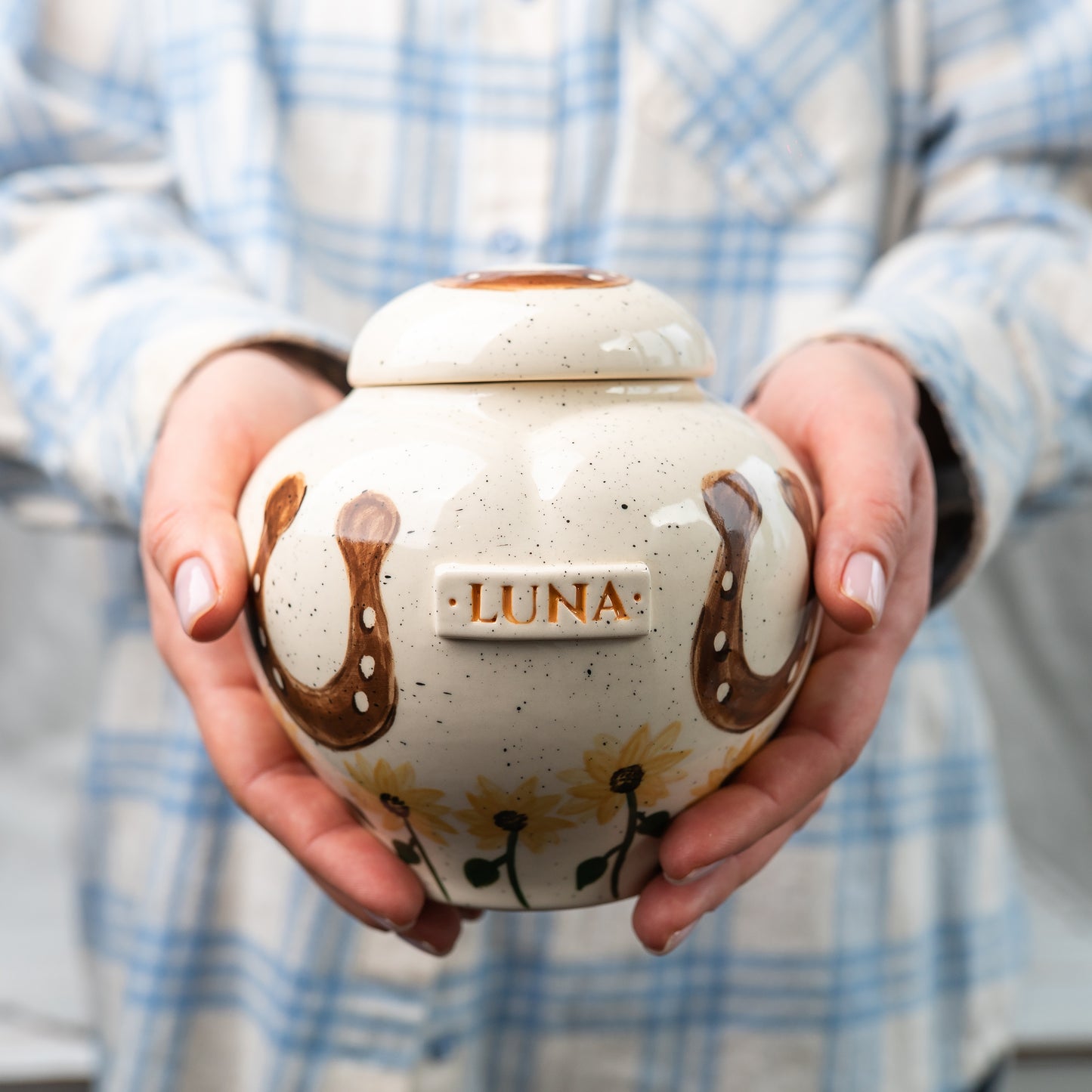 Showing the scale of a medium heart-shaped horse keepsake urn held in hands