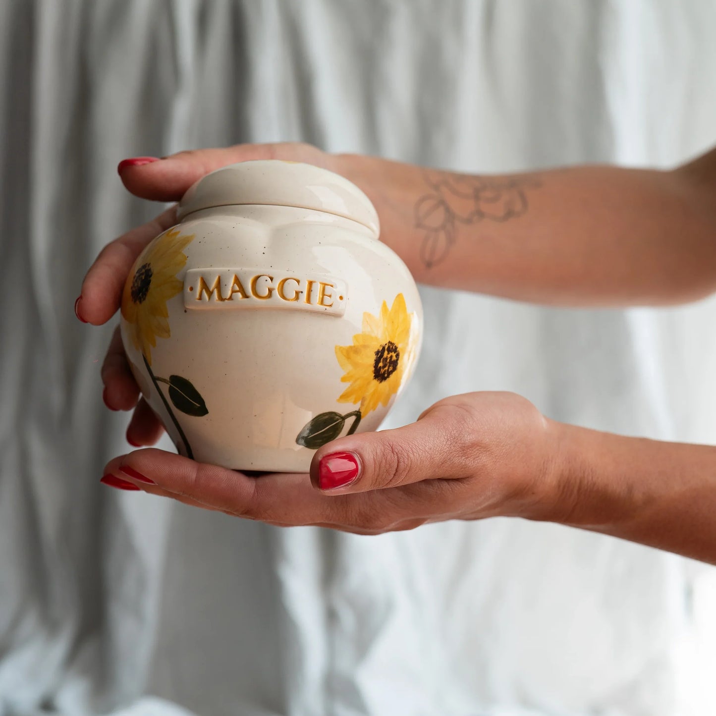 Holding a small sunflower heart keepsake urn for scale