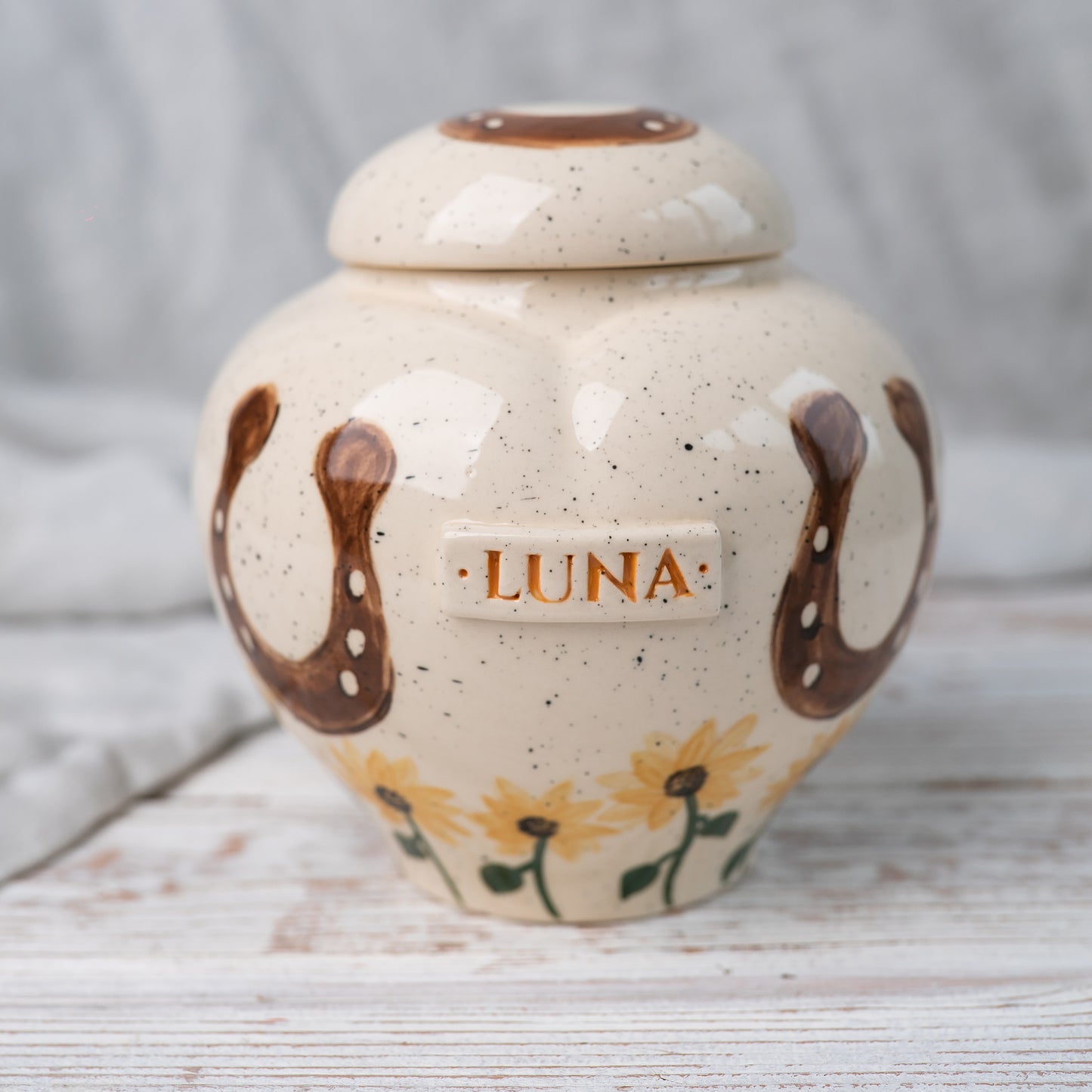 Front view of a handmade ceramic horse urn with hand-painted sunflowers