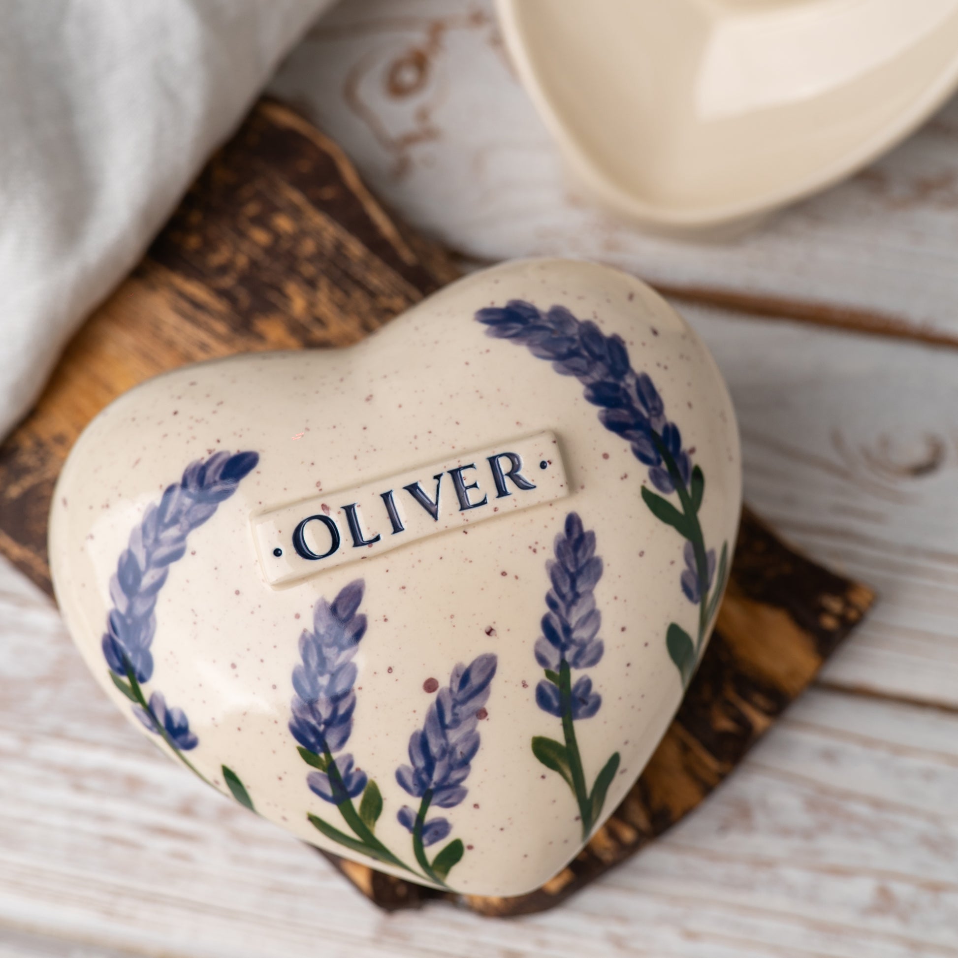 Top view of the ceramic heart urn, showing the detailed lavender petals and botanical sprig design.
