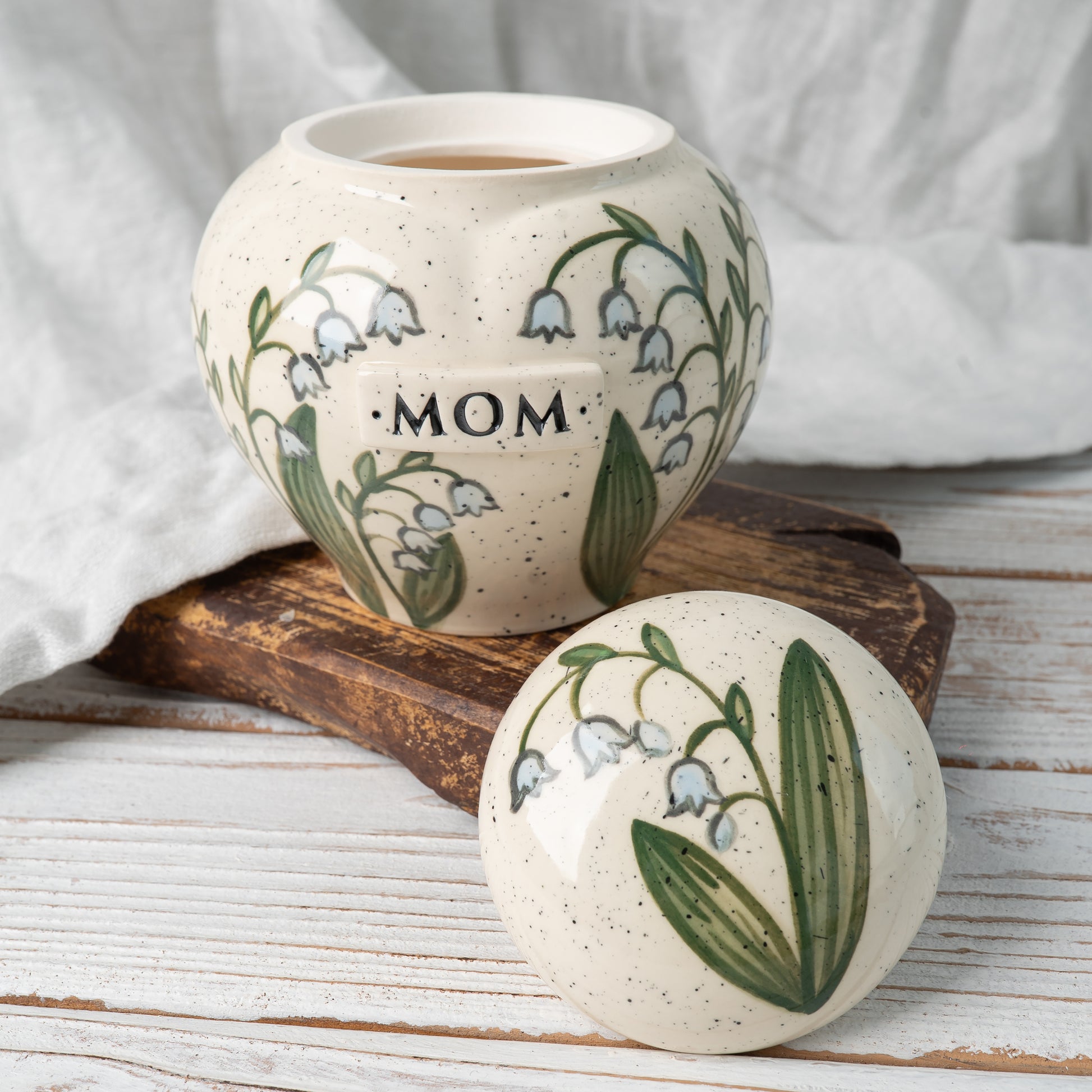 Custom lily of the valley flower ceramic urn shown open revealing inner chamber for ashes
