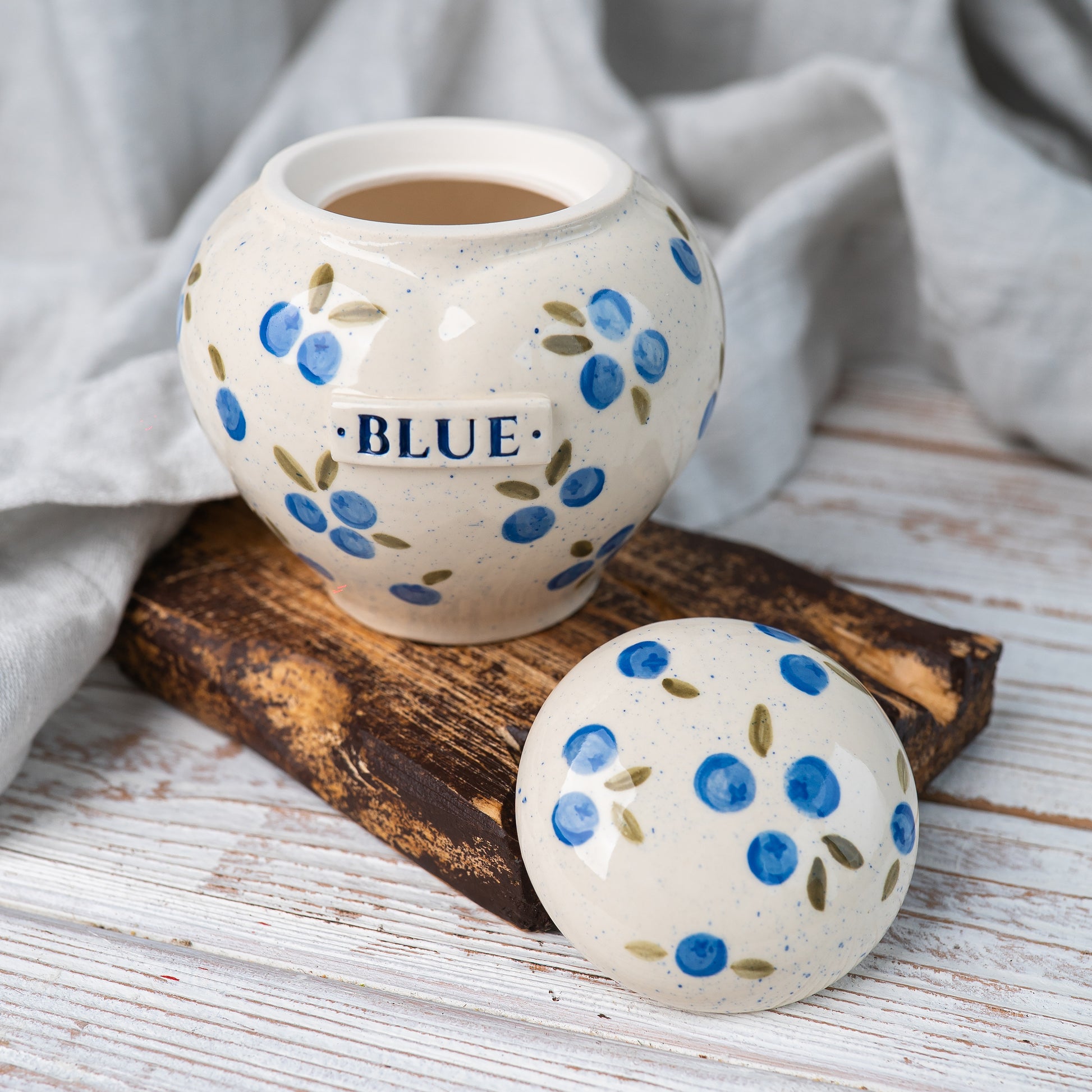 A photograph of the open blueberry pot-style heart urn with the lid removed, revealing the internal glaze.
