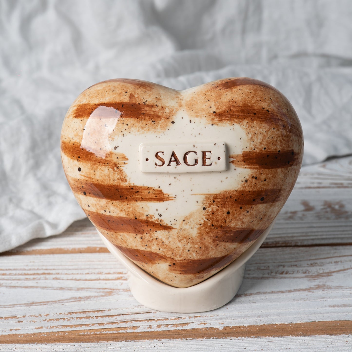 Hand-painted orange tabby cat heart-shaped ceramic urn with realistic ginger stripes and matching stand.