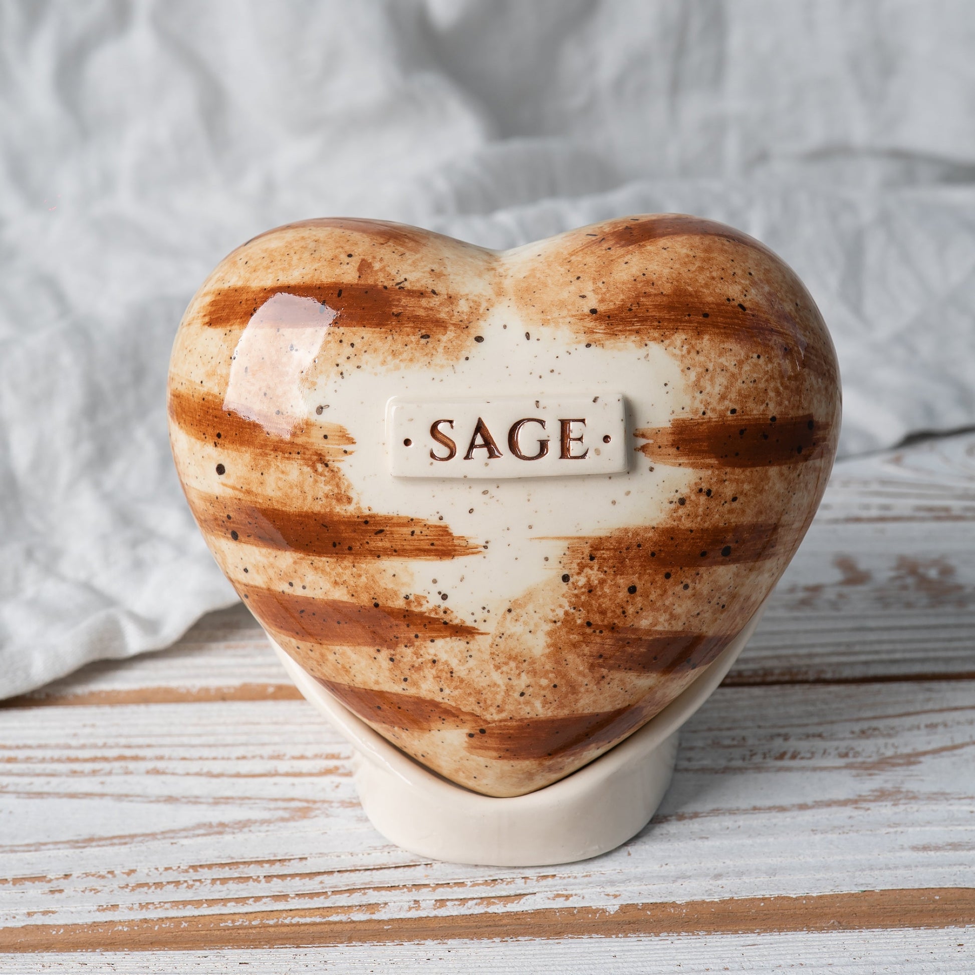 Hand-painted orange tabby cat heart-shaped ceramic urn with realistic ginger stripes and matching stand.