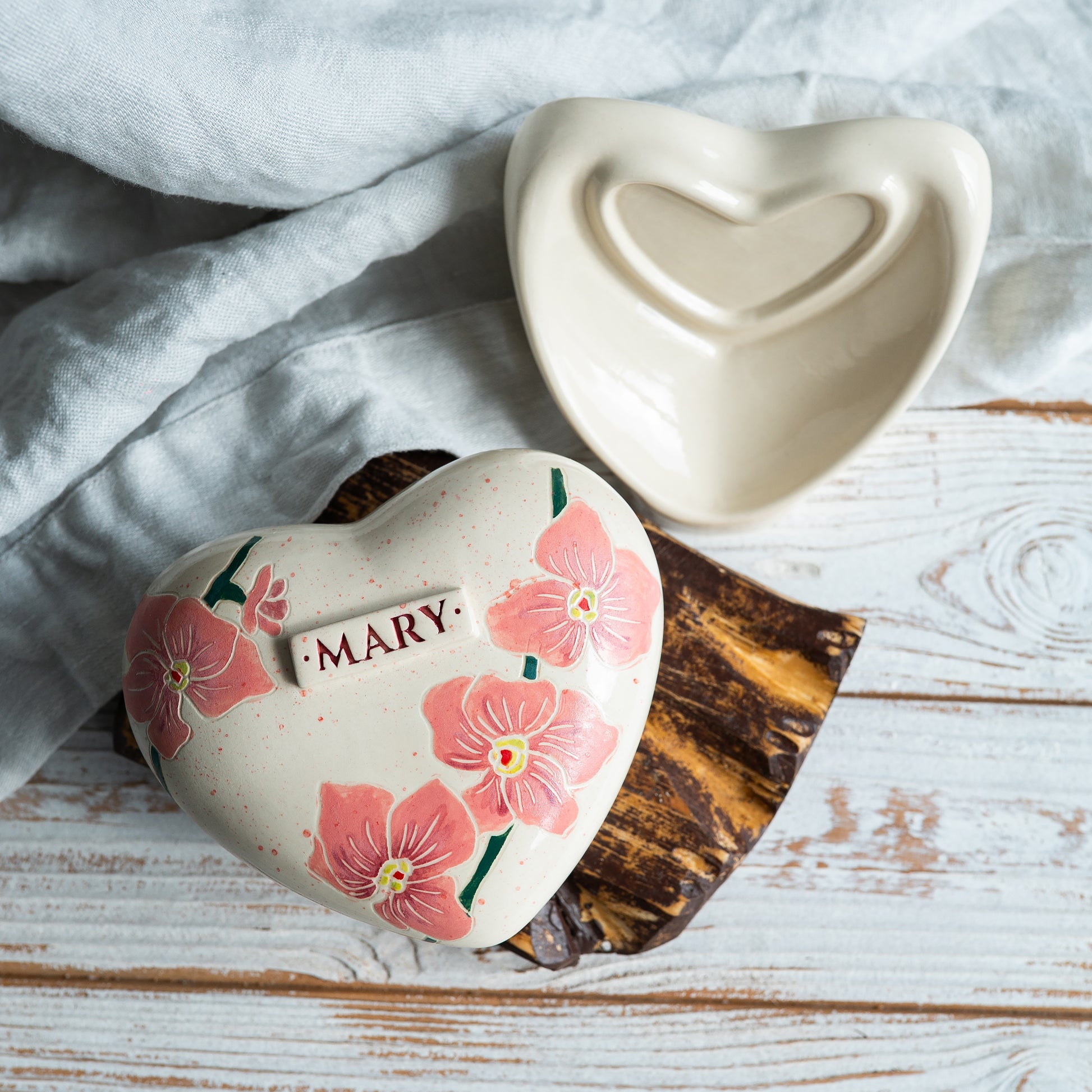 Top view of the heart-shaped ceramic urn, showing the detailed hand-painted orchid petals and minimalist design.