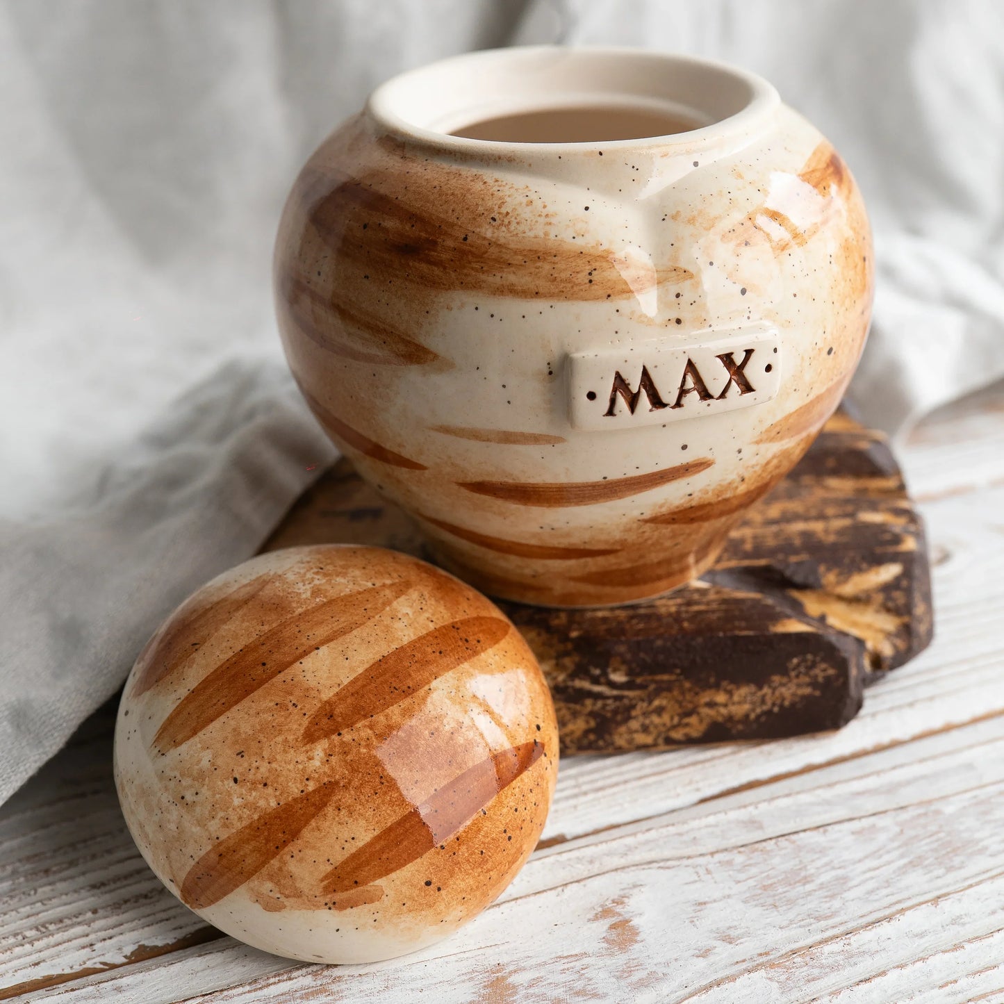 Overhead view of hand-painted orange tabby stripes on ceramic urn lid