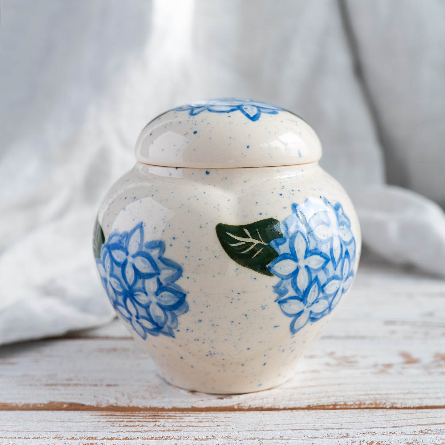 Back view of hand-painted hydrangea petals on ceramic urn 