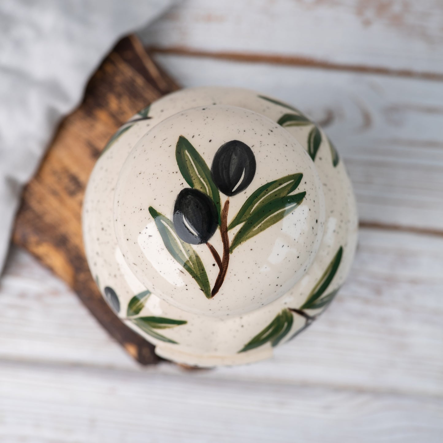 Overhead view of olive patterned ceramic urn lid