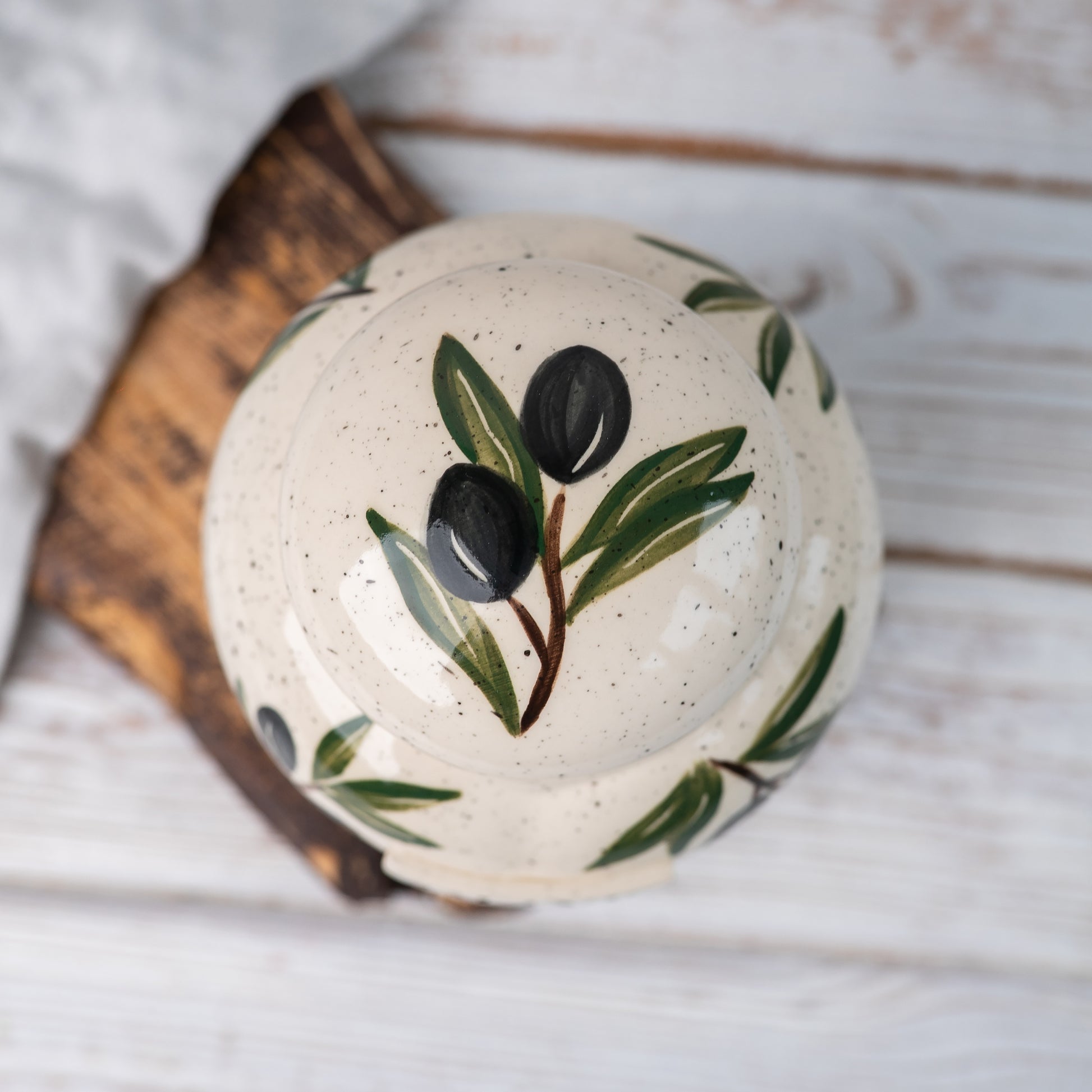Overhead view of olive patterned ceramic urn lid