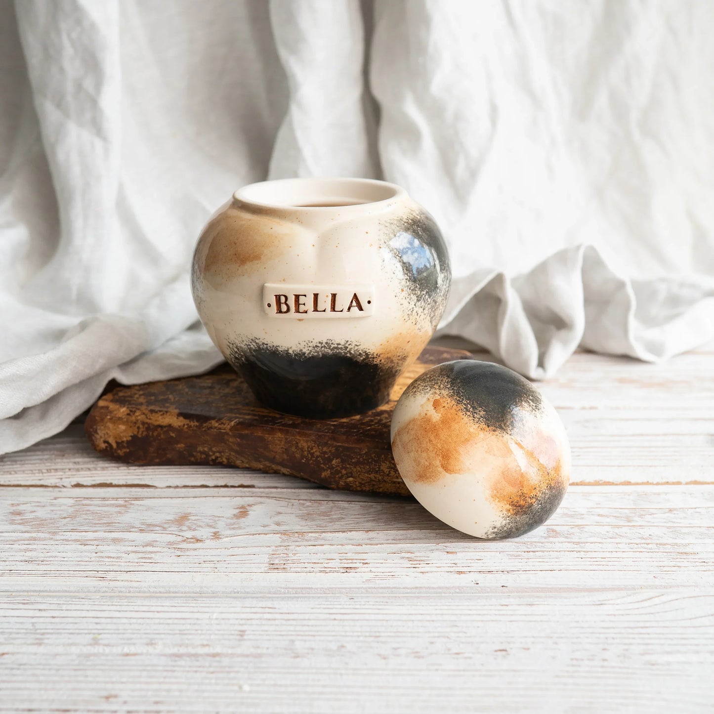 Close-up of open Calico tri-color ceramic heart cat urn by Mira Ceramics.