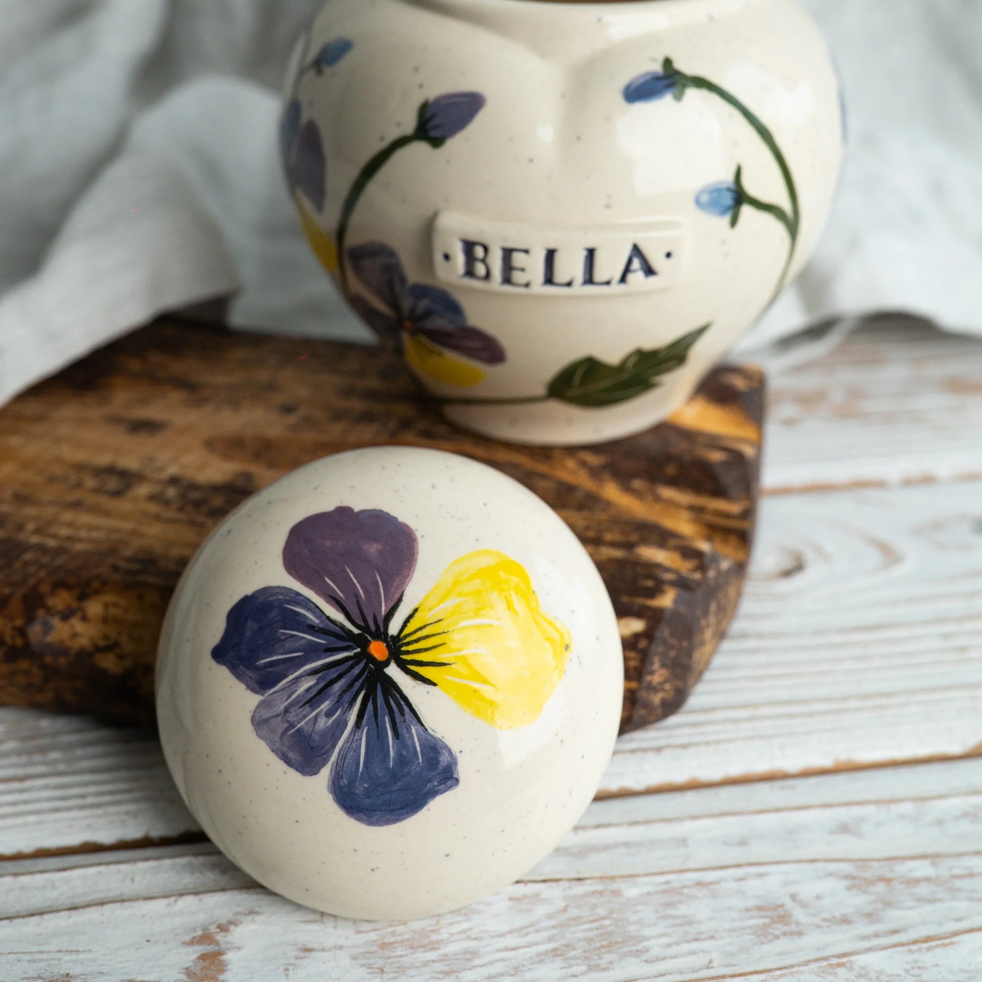 Close-up of open pansies ceramic heart urn detail