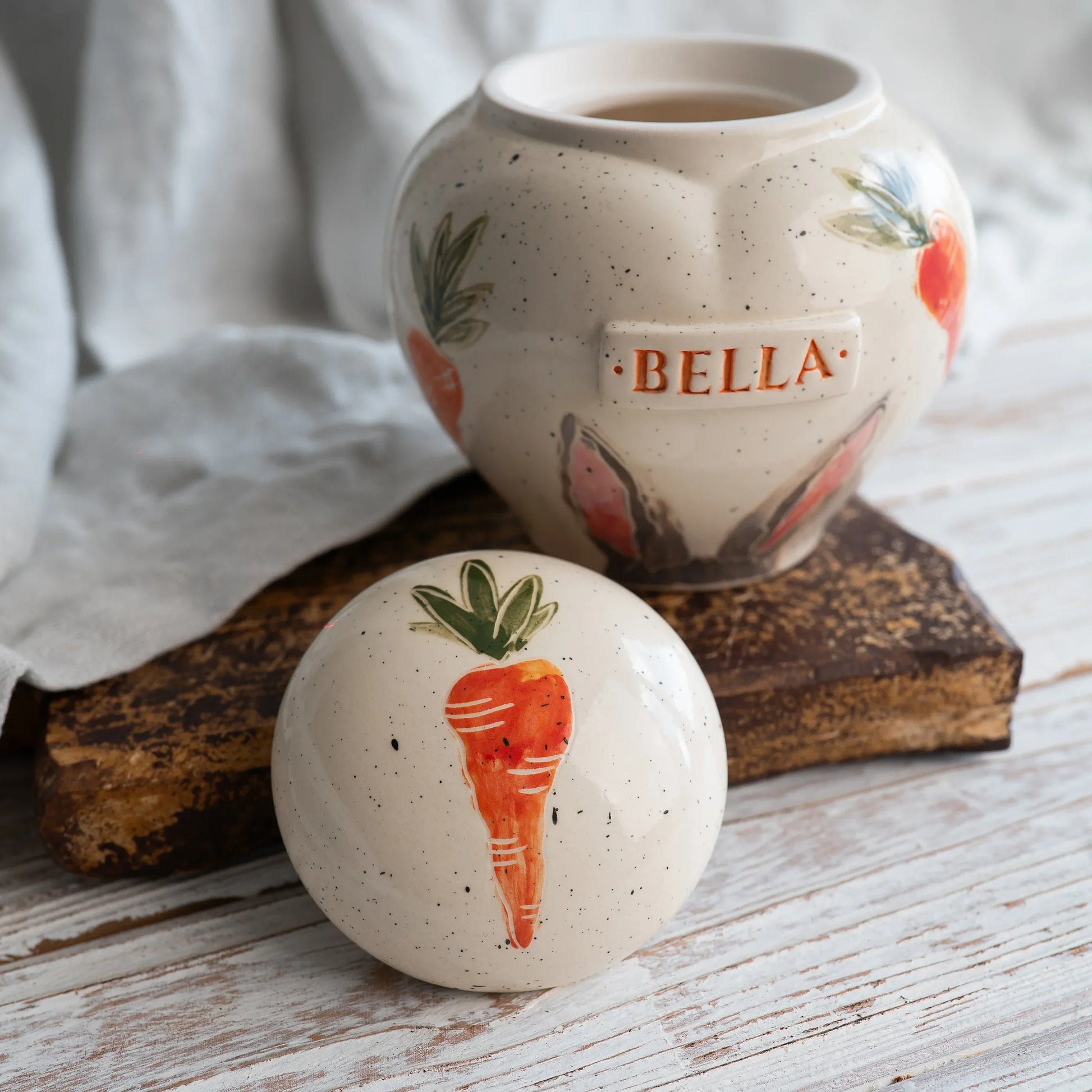 Close-up of open rabbit ears and carrots ceramic heart urn