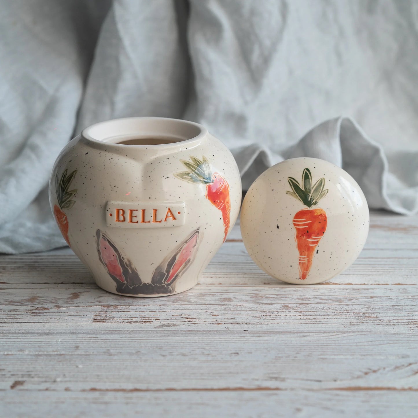 Close-up of open rabbit ears and carrots ceramic heart urn
