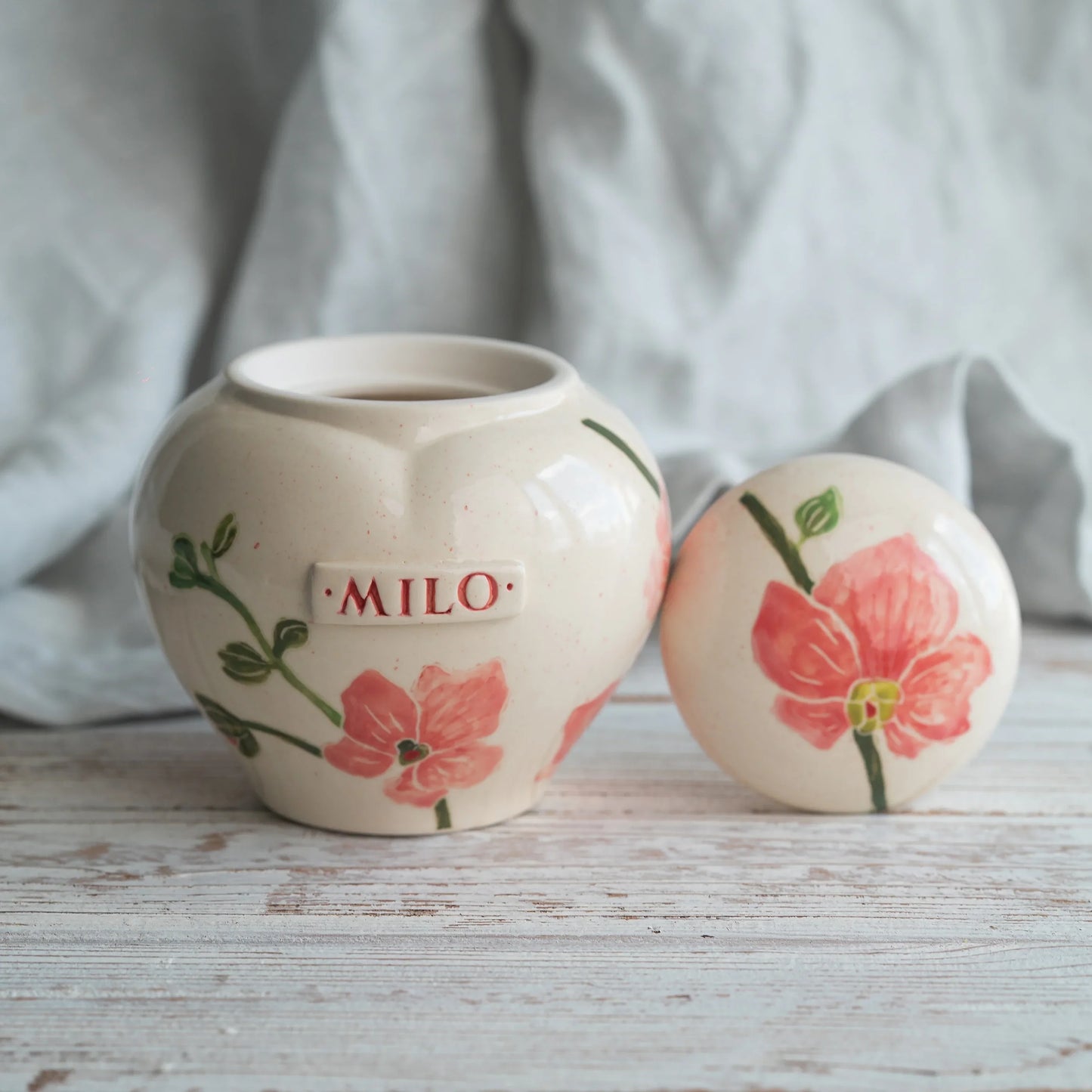 Top view of hand-painted orchid on ceramic urn lid by Mira Ceramics.