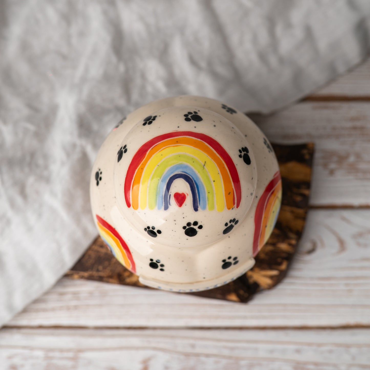 Top view of the heart-shaped pet memorial pot urn showing the hand-painted rainbow and ceramic lid.