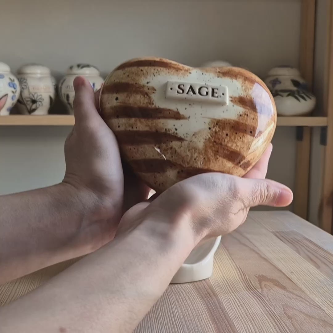 Video showcase of a hand-painted ginger tabby cat heart-shaped ceramic urn on a stand