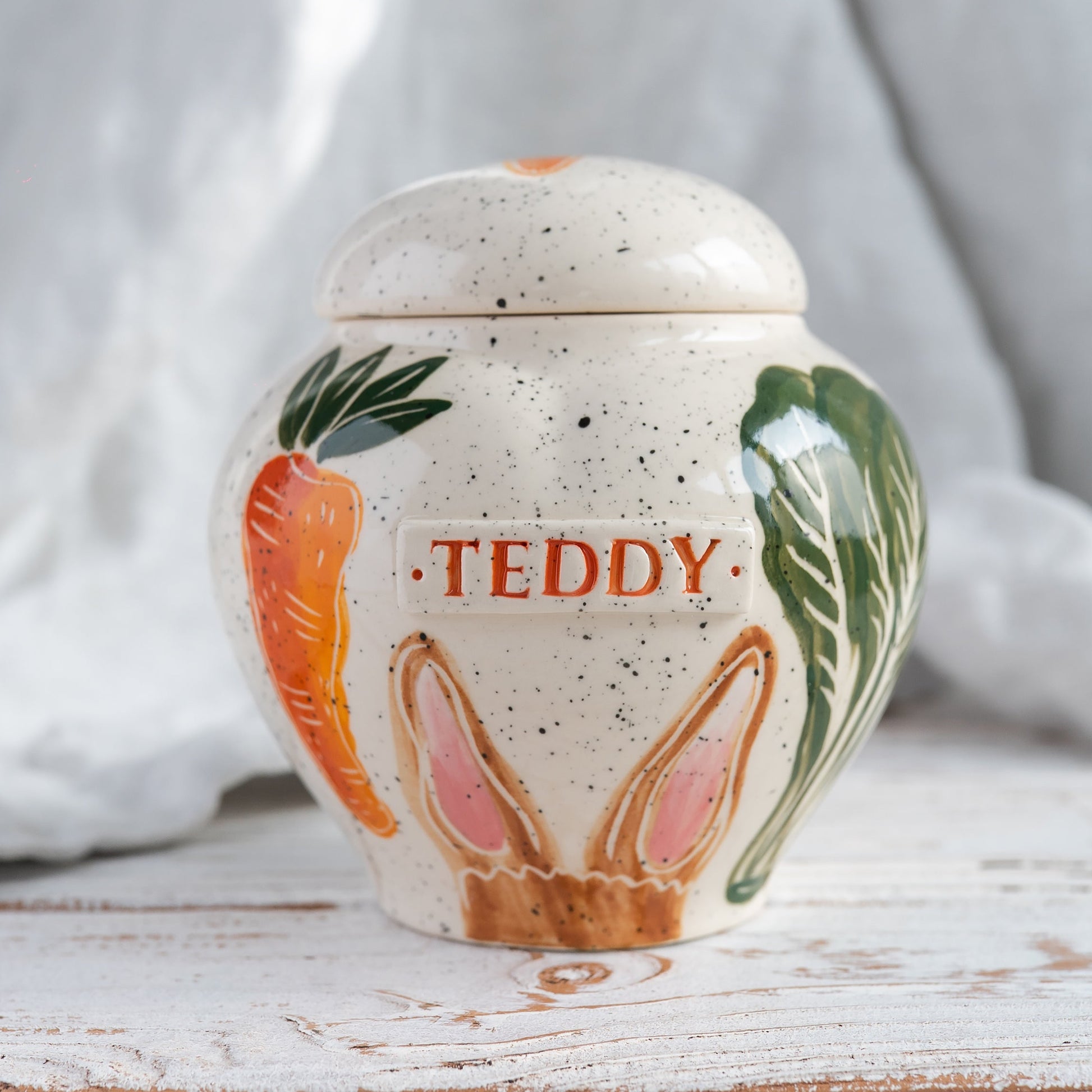 Hand-painted pot-style heart-shaped ceramic rabbit urn with carrots and cabbage for ashes.